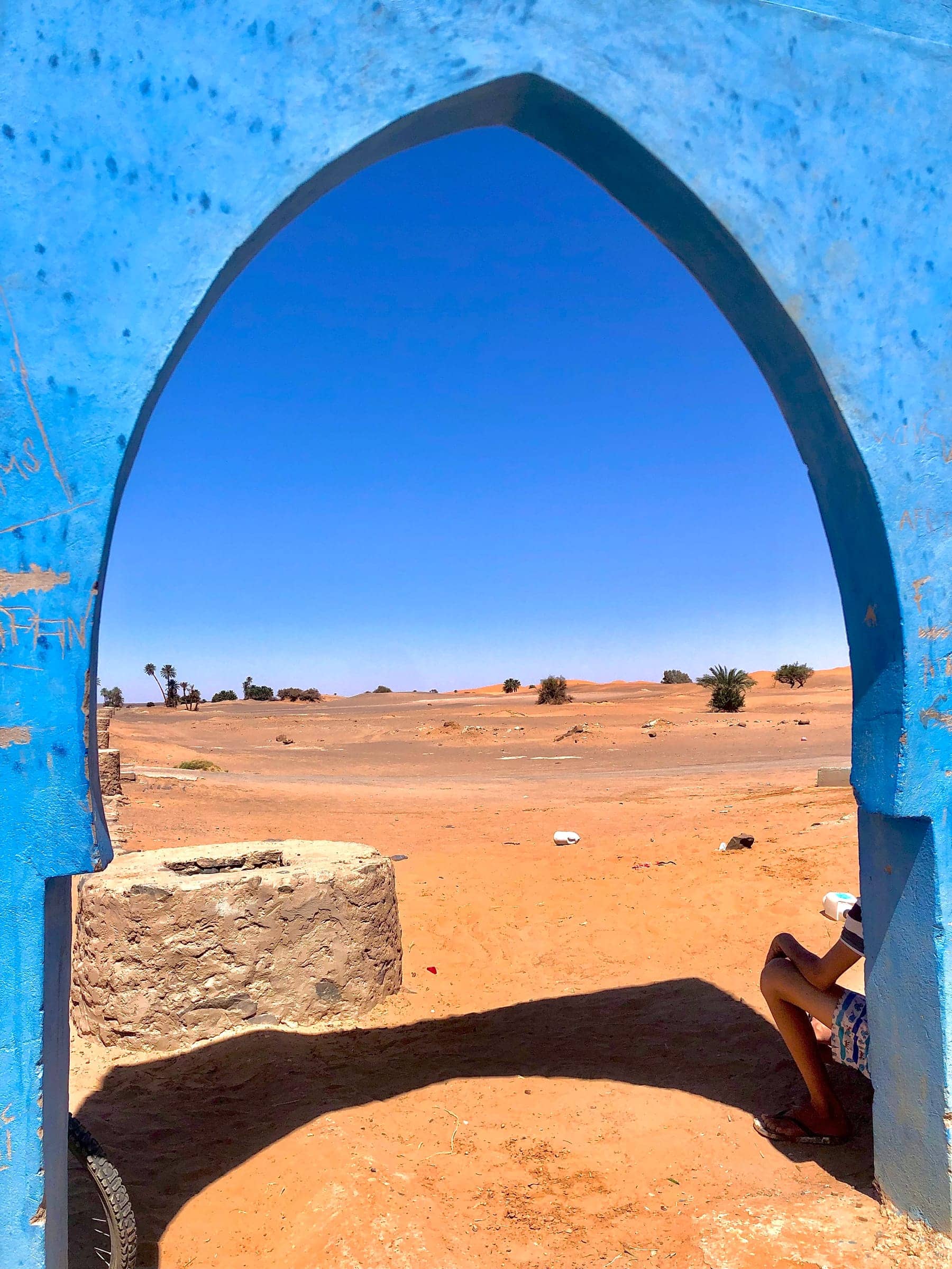 View of the Sahara through a blue Moroccan archway